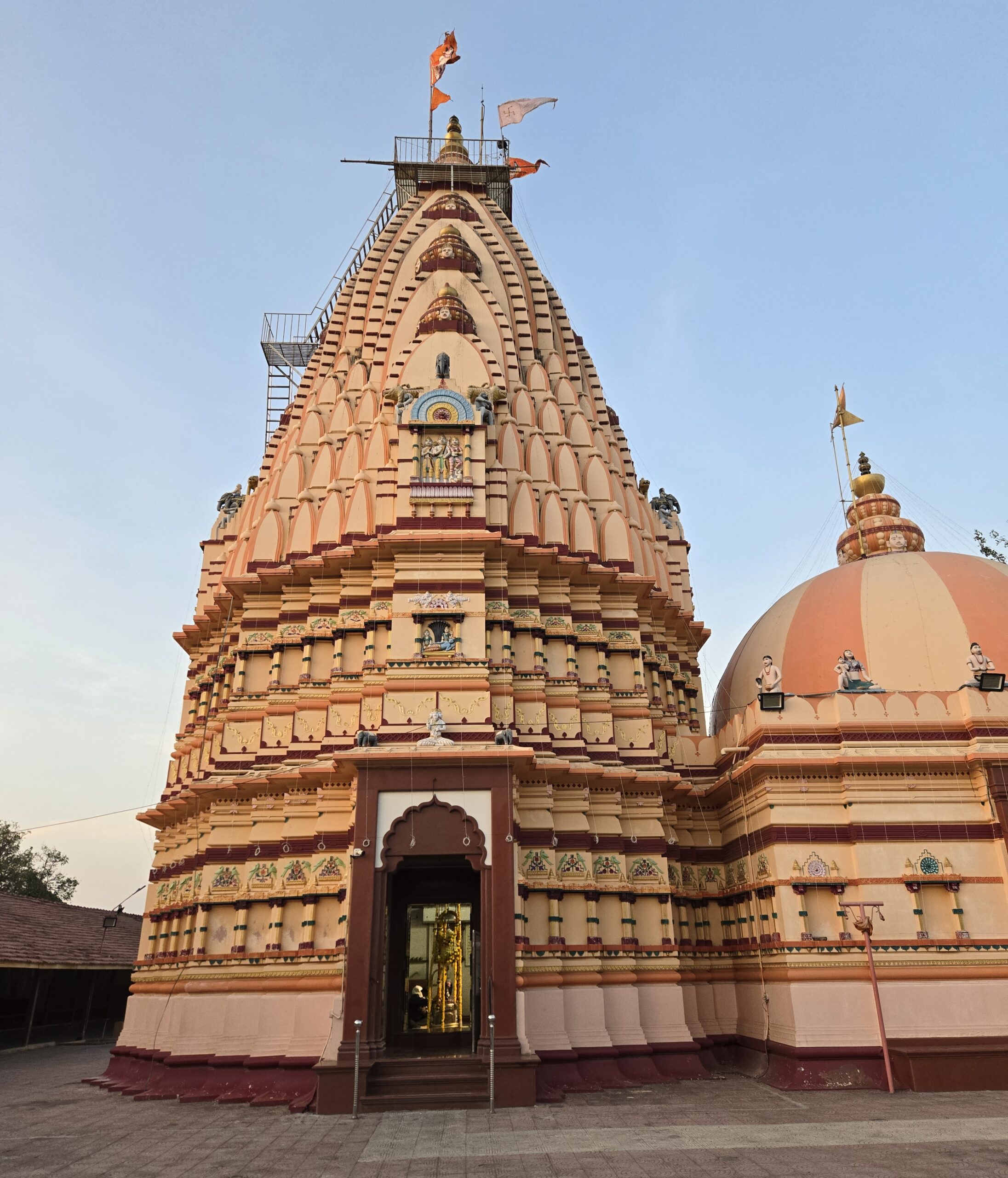 Peach and terracotta exterior of Shree Siddhnath Mahadev Mandir near Surat in the evening light