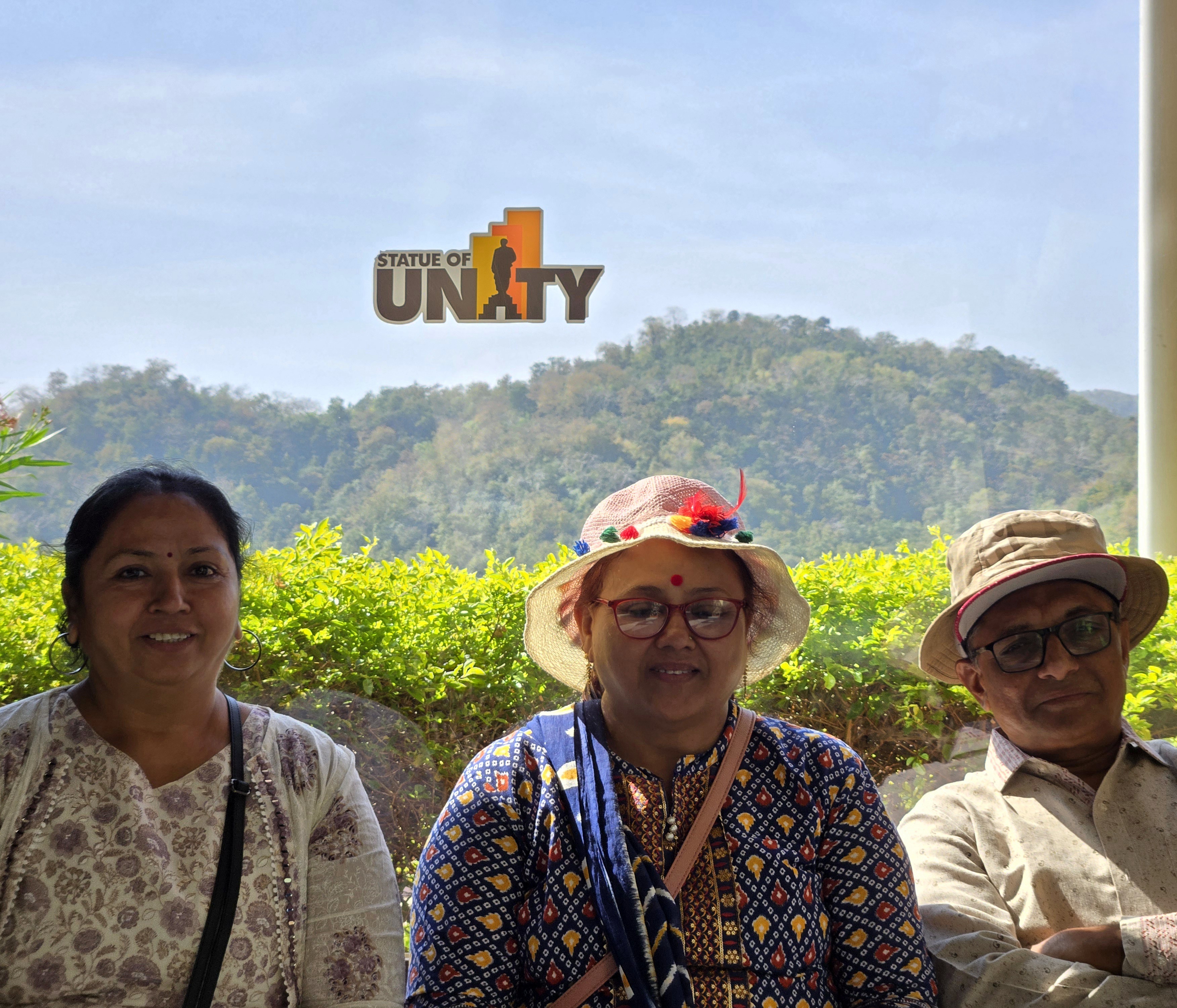 Three family members seated beneath a Statue of Unity window inside the monument