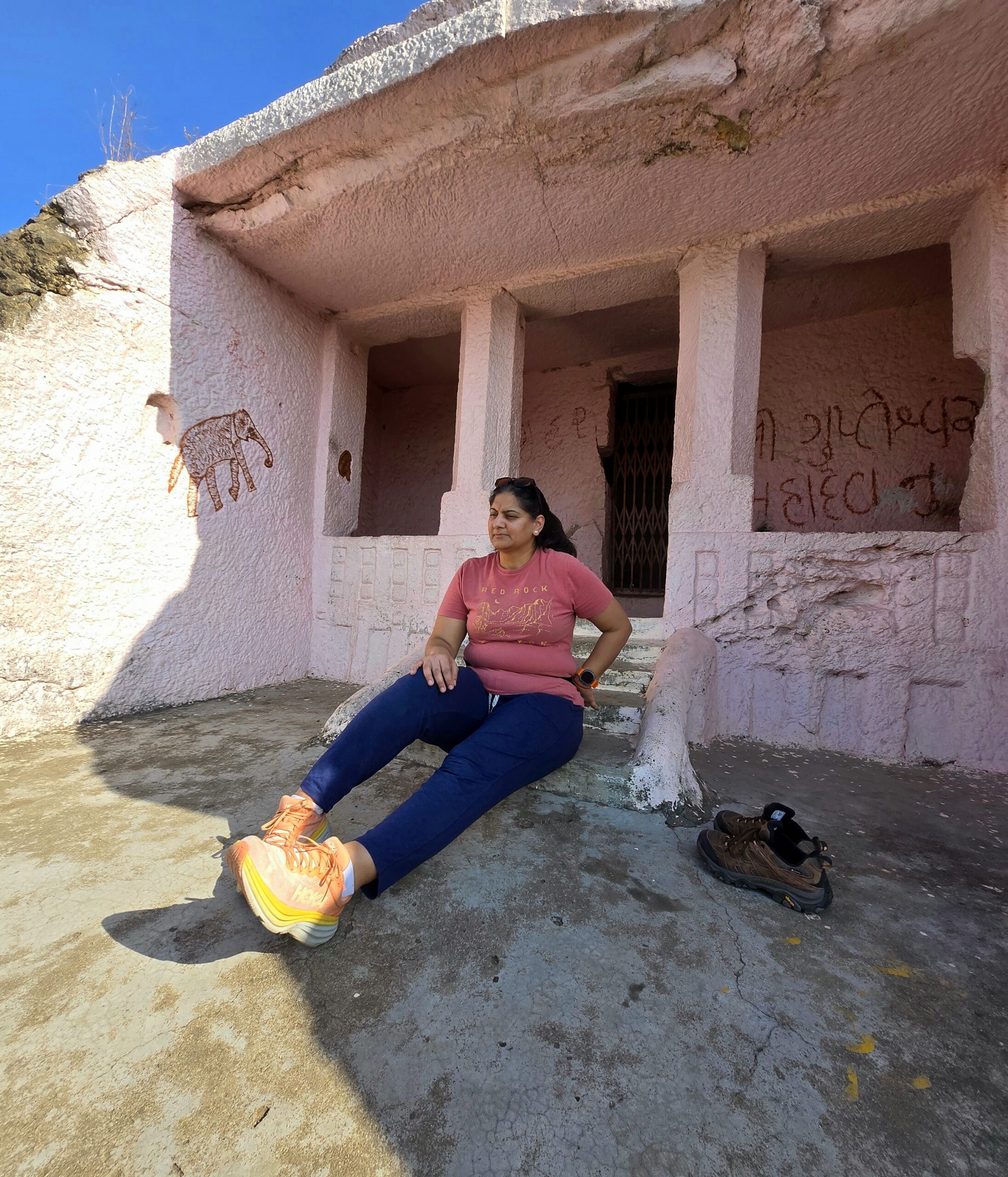 Ruby sitting outside the pink-painted second meditation room at Kadia Dungar