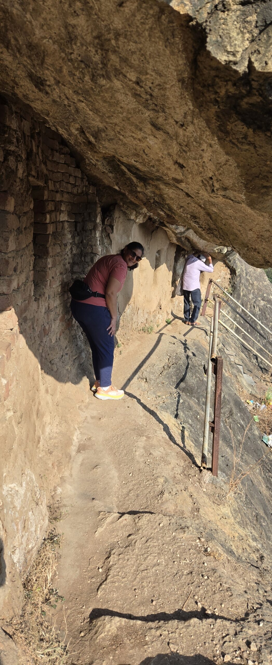 Ruby standing beneath the sandy rock ceiling of a large cave at Kadia Dungar