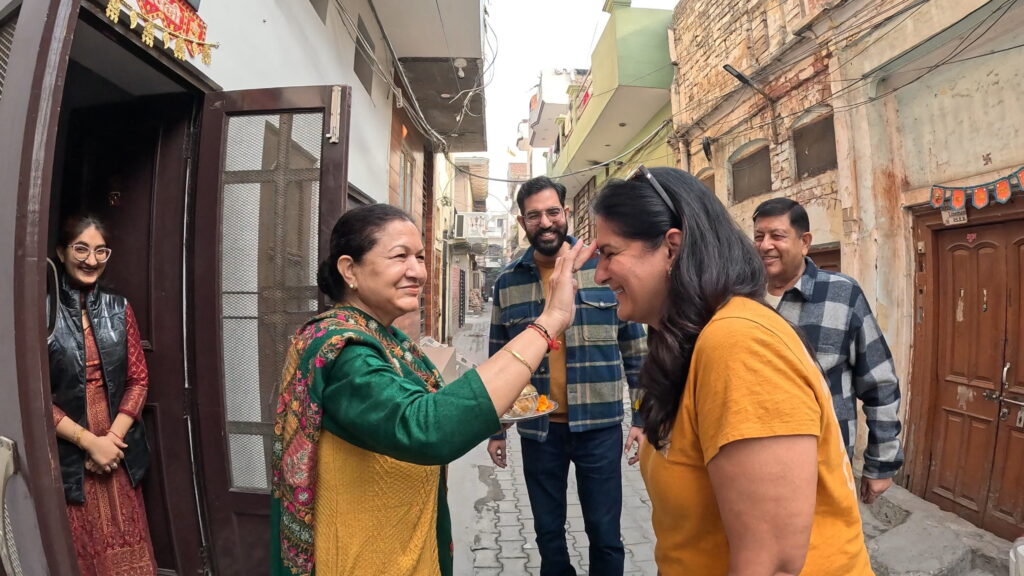 Nilam Chaachi placing a tilak on Ruby’s forehead during a traditional family welcome in Ferozpur