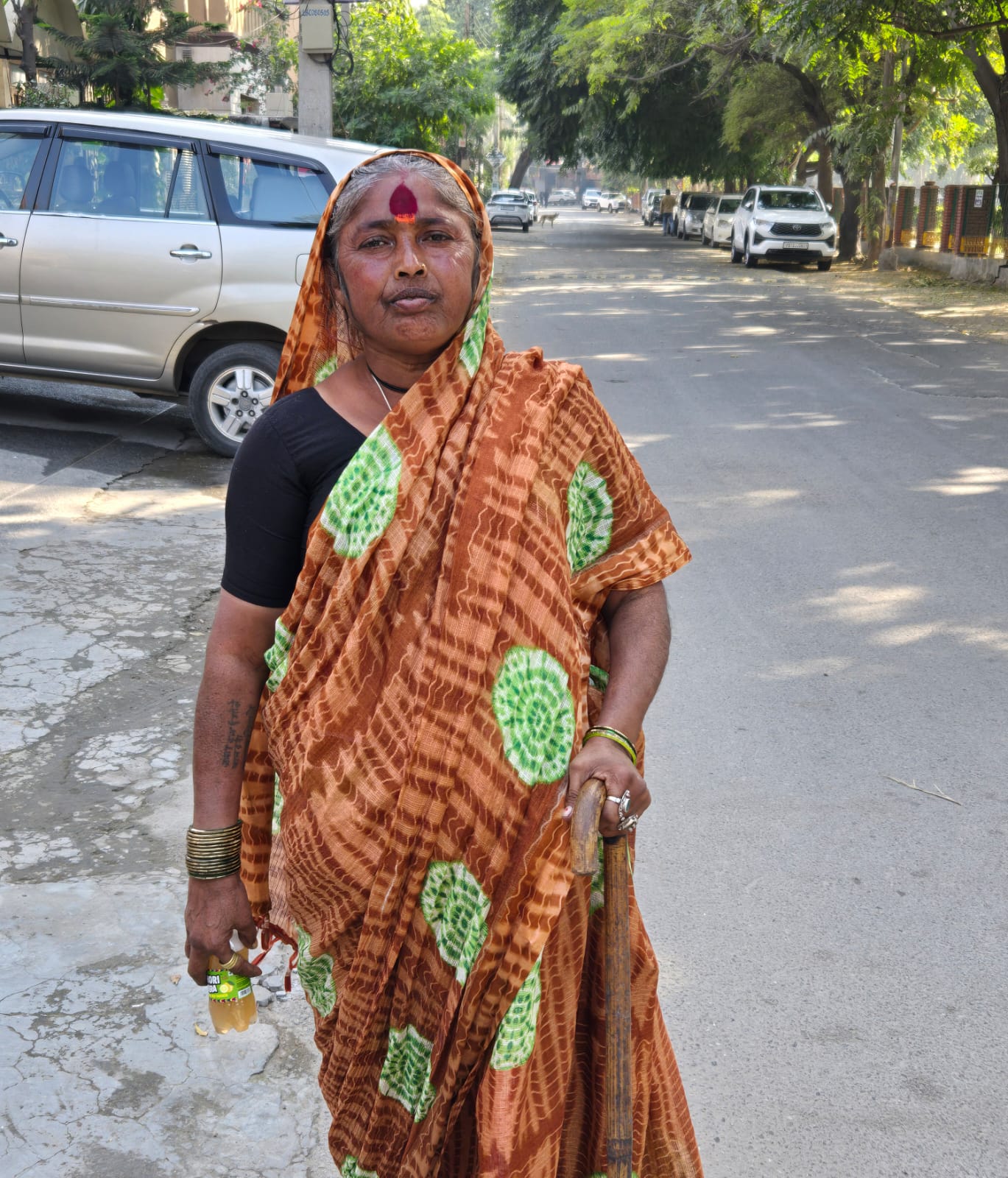Woman holding the electrolyte drink offered by traveling Shiva bhakts in Ludhiana